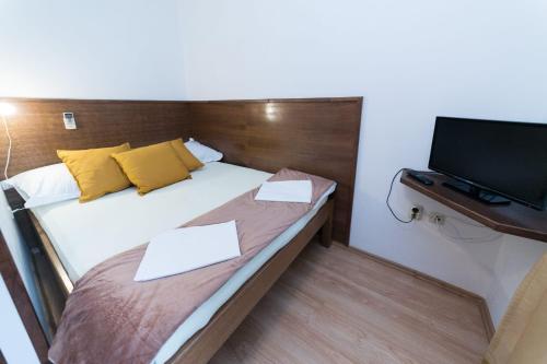 a small bedroom with a bed and a tv at MB Pag Bed&Breakfast in Pag