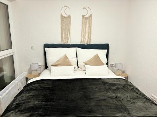 ein Schlafzimmer mit einem großen Bett mit weißen Kissen in der Unterkunft Charming Homes - Studio 20 in Wolfsburg