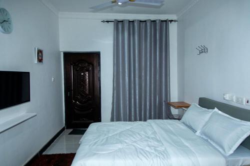a bedroom with a bed and a television in it at BryMac Hotel in Koforidua