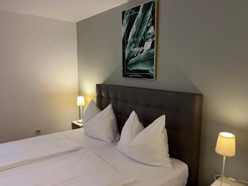 ein Hotelzimmer mit einem Bett mit weißen Kissen in der Unterkunft Pension Waldesruh in Bad Ischl