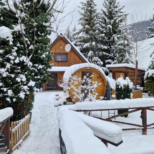a cabin in the winter with snow on the ground at Chalúpka Sokolí dvor s wellnesom in Terchová