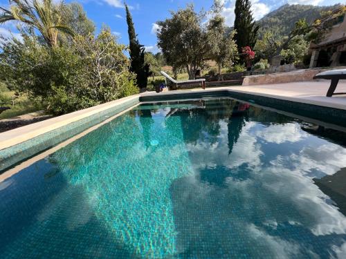 a swimming pool with blue water in a yard at Finca CanFirella Portocolom in Felanitx