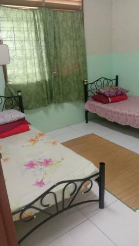 Ένα ή περισσότερα κρεβάτια σε δωμάτιο στο Homestay Hajah Zainab Linggi Negeri Sembilan