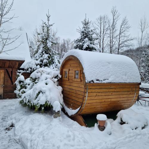 a small wooden cabin with snow on its roof at Chalúpka Sokolí dvor s wellnesom in Terchová