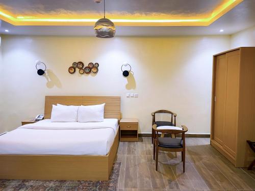 um quarto de hotel com uma cama e uma cadeira em Address hotels and towers em Abuja