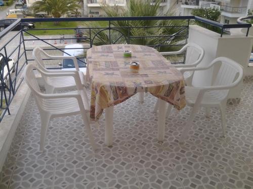 a table and four chairs on a balcony at Esperides Villas in Fourka