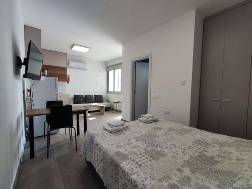 a bedroom with a bed and a table and a kitchen at St. Lazaros Studios 2 in Larnaka