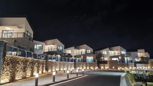 a row of lights in front of a building at night at Ddosi Aewol Pool Villa in Jeju