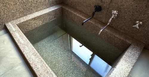 a bath tub with a shower in a bathroom at EXP Co Onsen 呼隱撰 in Atami