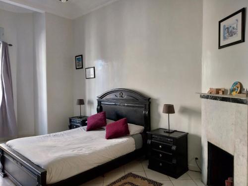 - une chambre avec un lit doté d'oreillers rouges et une cheminée dans l'établissement Cosy Art Deco Apart, à Casablanca