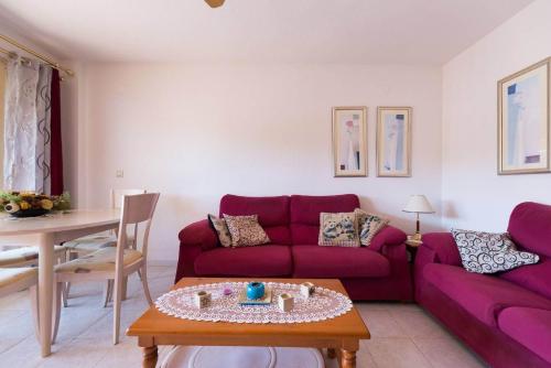 ein Wohnzimmer mit einem roten Sofa und einem Tisch in der Unterkunft Apartamento Zeus 4 - PlusHolidays in Calpe