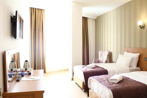 Cette chambre comprend deux lits et un bureau. dans l'établissement Melidium Hotel, à Beylikduzu