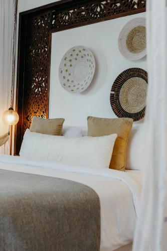 a bedroom with a bed with white sheets and pillows at LUX* Marijani Zanzibar in Pwani Mchangani