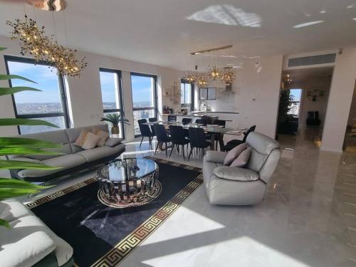 a living room with couches and a dining room and kitchen at JTower Royal Suites - The Penthouse - Alefimmoed in Jerusalem