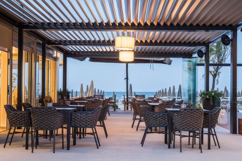 a restaurant with tables and chairs and a view of the ocean at Hotel Majestic in Milano Marittima