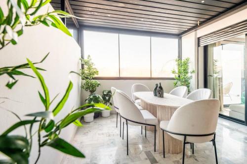 ein Esszimmer mit einem Tisch, Stühlen und Pflanzen in der Unterkunft TTHOLIDAYS Cosy Apartment Casablanca City Center in Casablanca