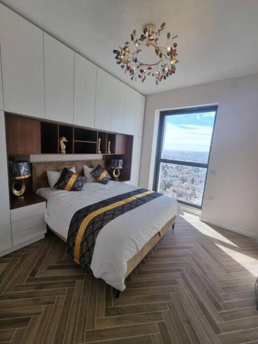 a bedroom with a large bed and a large window at JTower Royal Suites - The Penthouse - Alefimmoed in Jerusalem