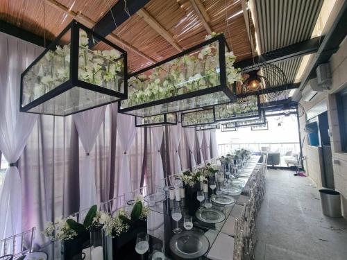 a long table in a room with flowers on it at JTower Royal Suites - The Penthouse - Alefimmoed in Jerusalem
