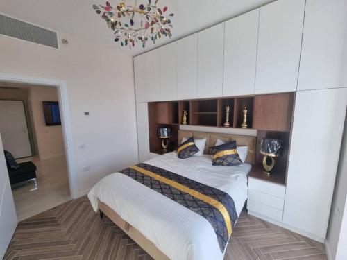 a bedroom with a large bed with white cabinets at JTower Royal Suites - The Penthouse - Alefimmoed in Jerusalem