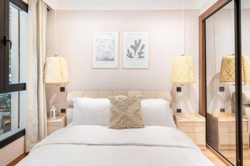 - une chambre avec un grand lit blanc et deux lampes dans l'établissement TTHOLIDAYS Cosy Apartment Casablanca City Center, à Casablanca