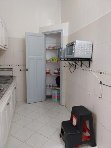a kitchen with a microwave and a stool in a room at Cosy Art Deco Apart Welcome to James's in Casablanca