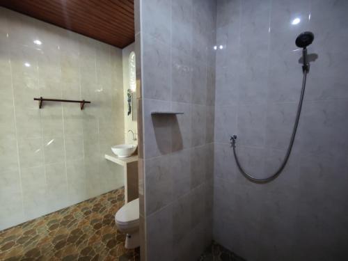 a bathroom with a shower and a toilet and a sink at Alamku Bungalow in Tirtagangga