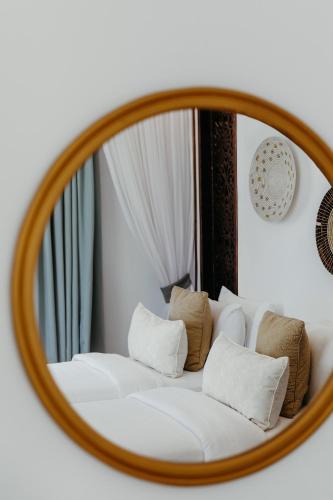 a mirror reflecting a bed with white pillows at LUX* Marijani Zanzibar in Pwani Mchangani