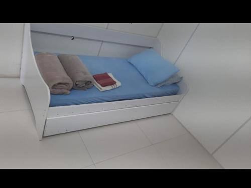 Una cama pequeña con toallas y almohadas. en VS HOSPEDAGEM en Cascavel
