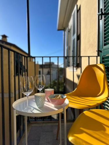 a table and two chairs on a balcony with wine glasses at Al Castello 1 in Riomaggiore