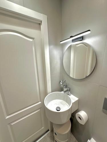 a white bathroom with a sink and a mirror at Al Castello 1 in Riomaggiore