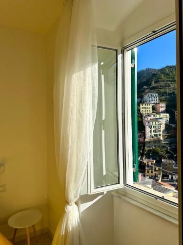 a window with a curtain and a view of a city at Al Castello 1 in Riomaggiore