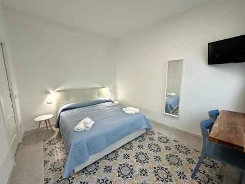 een slaapkamer met een bed met blauwe lakens en een spiegel bij Al Castello 1 in Riomaggiore