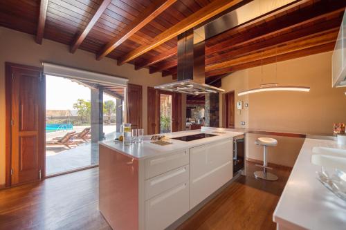 a kitchen with white cabinets and a view of a pool at Villa Atlanntes con piscina en Fuerteventura in Triquivijate