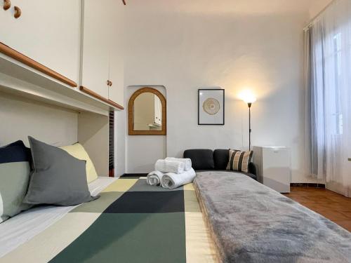 a bedroom with a large bed and a couch at La Casa di Eli Appartamenti in Pisa