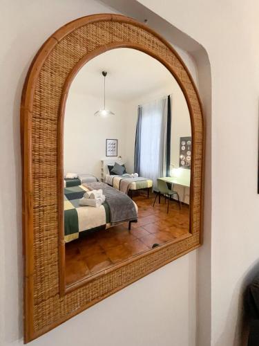 a mirror in a room with a bed and a bedroom at La Casa di Eli Appartamenti in Pisa