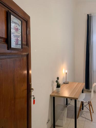 a room with a wooden table and a wooden door at La Casa di Eli Appartamenti in Pisa