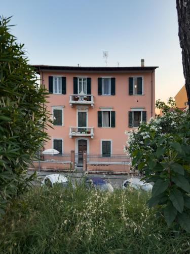 a pink house with a balcony in front of it at La Casa di Eli Appartamenti in Pisa