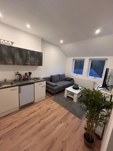 een keuken en een woonkamer met een bank en een tafel bij Apartment Södderich 2 in Waake