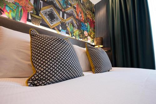een slaapkamer met een bed met 2 kussens erop bij Hyde Park Green in Londen