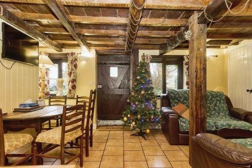 a christmas tree in a living room with a table at Lavender Cottage in Arreton