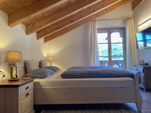 a bedroom with a bed with two pillows and a window at Ferienwohnungen LARA Wohnung 3 in Wallgau