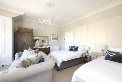 uma sala de estar com duas camas e um sofá em The Howard Apartment nr The Old Course em St. Andrews