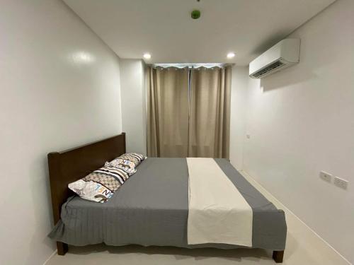 1 dormitorio con cama y ventana en Room 703 Pontefino Hotel, en Batangas