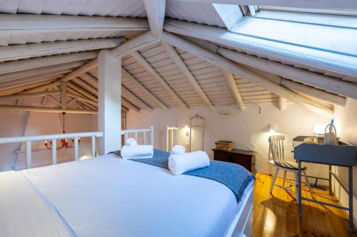 a bedroom with a white bed and a window at Casa dos Cantoneiros in Aljezur