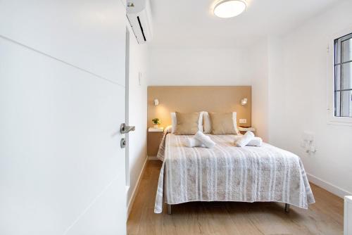 ein weißes Schlafzimmer mit einem Bett und einem Fenster in der Unterkunft Liomor Luxury in Caleta de Fuste