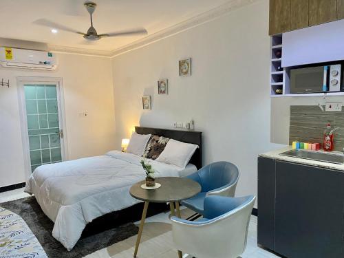a bedroom with a bed and a table and chairs at BryMac Hotel in Koforidua