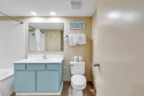 a bathroom with a toilet and a sink and a mirror at Oceanfront 1BR Condo, Your Coastal Escape at Atlantica in Myrtle Beach