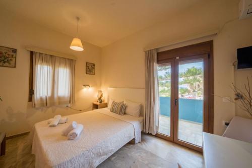 a bedroom with a bed and a large window at Frank Apartments in Amoudara Herakliou
