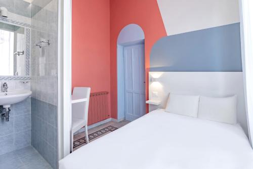 1 dormitorio con 1 cama y baño con lavamanos en Hotel Infinito - Gruppo BLAM HOTELS, en Roma