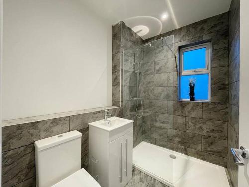 a bathroom with a toilet and a shower and a window at Solace in Bournemouth